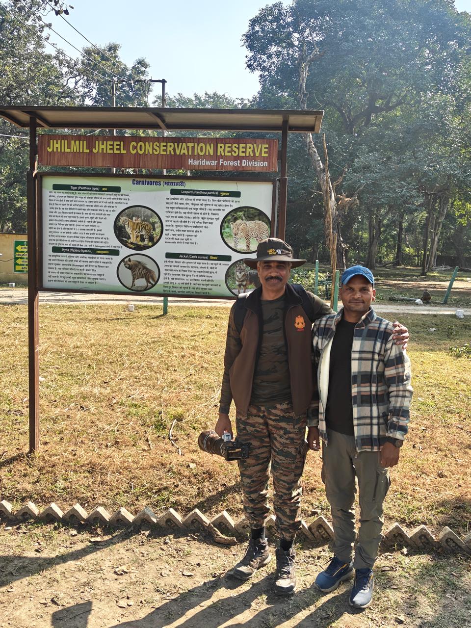 Tourists standing at Jhilmil Jheel entry information board